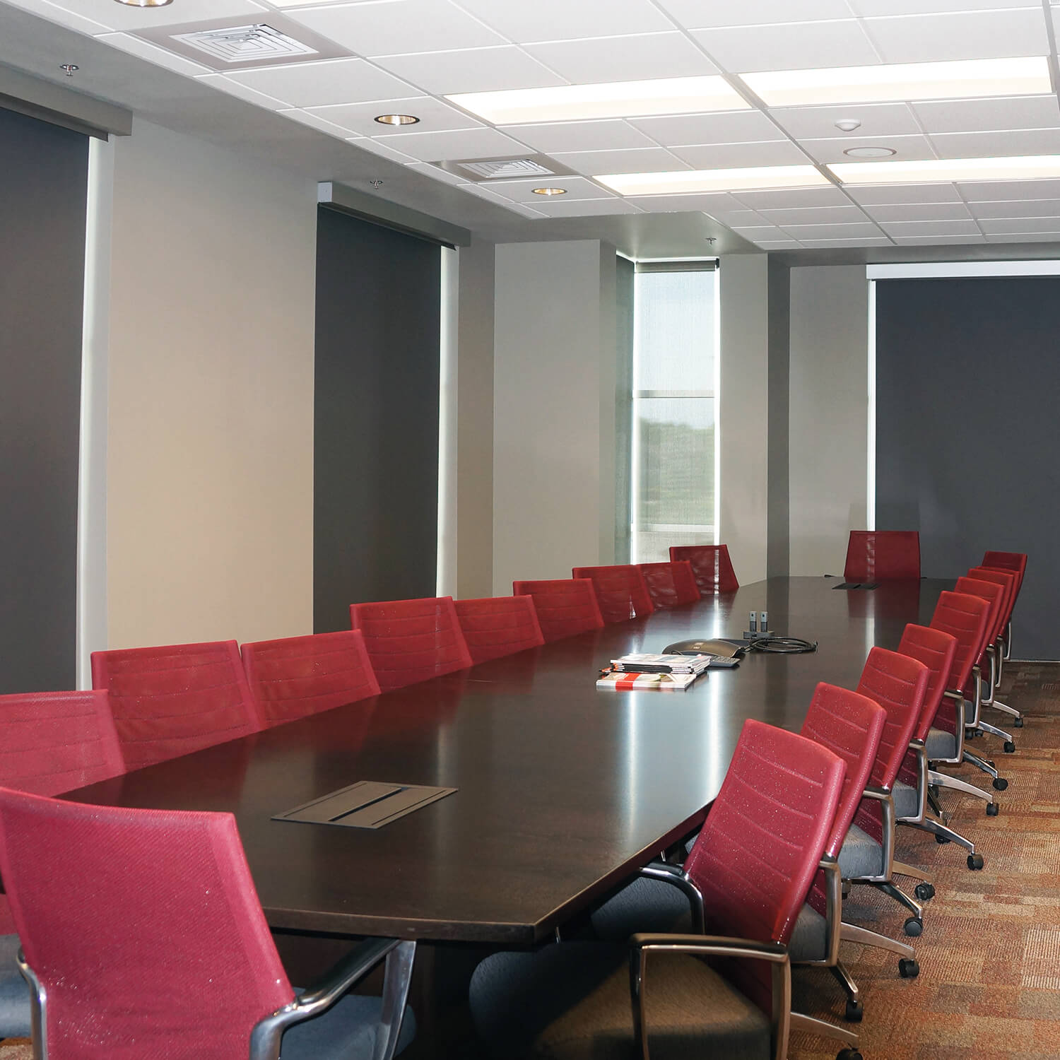 Insolroll blackout and solar dual shades in company conference room with red chairs
